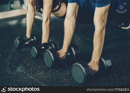Closeup hand Couple diversity working out in gym fitness sport complex, workout working out arms and cardio,posture position, Push up on weights,Doing plank on kettlebell.sports and healthcare concept