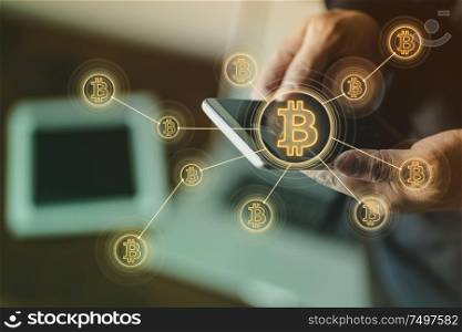 Closeup hand holding smartphone buy or sell virtual currency Bitcoin .Electronic money ,blockchain transfers and finance concept.