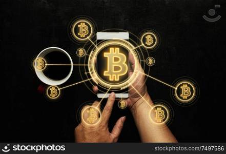 Closeup hand holding smartphone buy or sell virtual currency Bitcoin .Electronic money ,blockchain transfers and finance concept.