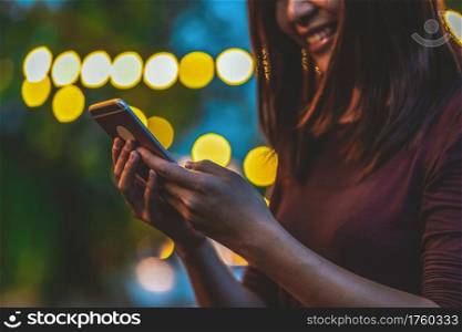 Closeup hand of Asian woman using smartphone and touching screen at outdoor park, Business and Lifestyle concept