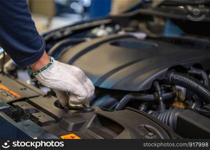 Closeup hand of auto mechanic examine car engine breakdown problem in front of automotive vehicle car hood. Safety technical inspection care check service maintenance for customer before road trip