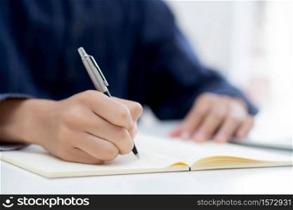 Closeup hand of man writing on notebook with pen on desk, freelance is author, businessman write on notepad on table, book, letter and report, finance and document, business or education concept.