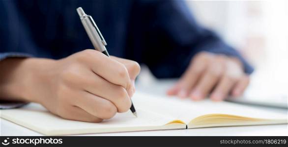 Closeup hand of man writing on notebook with pen on desk, freelance is author, businessman write on notepad on table, book, letter and report, finance and document, business or education concept.