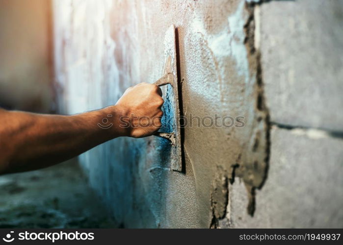 closeup hand of worker plastering cement at wall for building house