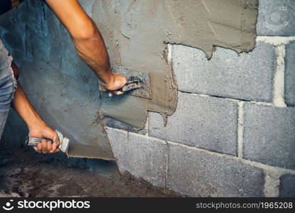 closeup hand of worker plastering cement at wall for building house