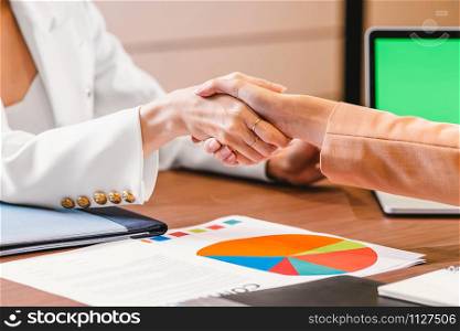 Closeup Hand shaking between Two asian businesswomen working with the partner business after success agreement and goal in modern meeting room, office or working space, partner and colleague concept