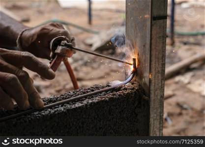 closeup hand welding metal in construction site