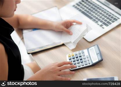 closeup hand woman calculating expenses household and writing notebook on desk, girl checking bill and stress and note, female worry debt and tax, finance and business concept.