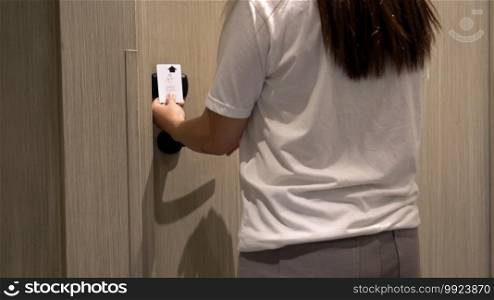 Closeup hand woman using an electronic security key card for opens the door of her hotel room, holiday and leisure concept