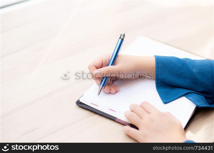 Closeup hand woman writer thinking idea and writing on notebook or diary with happy, lifestyle of asian girl is student, female planning working, education and business concept.