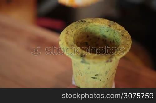 Closeup hands filling with spoon edible baked cone with hot vegetable soup and serving with mint leaf