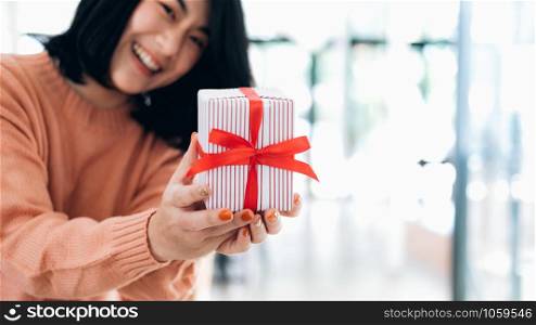 Closeup hands holding gift box of happy smiling young woman.