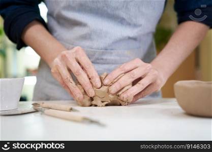 Closeup hands of ceramic artist wedging clay in art studio.. Closeup hands of ceramic artist wedging clay in art studio