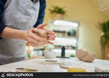 Closeup hands of ceramic artist wedging clay in art studio.. Closeup hands of ceramic artist wedging clay in art studio