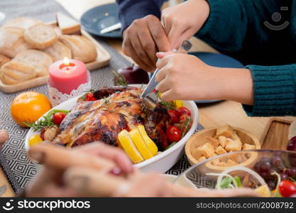 Closeup hands of children using knife slicing meat of turkey roasted on dishes for eating at home on thanksgiving eve day, celebration of xmas with dining with family, new year, festive and holiday.