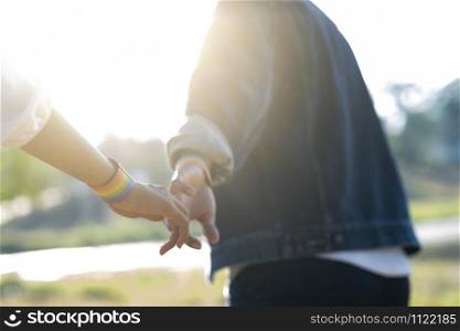 Closeup hands of LGBT lesbian couple. Couple of LGBT holding hands walking in the park. LGBT right concept.
