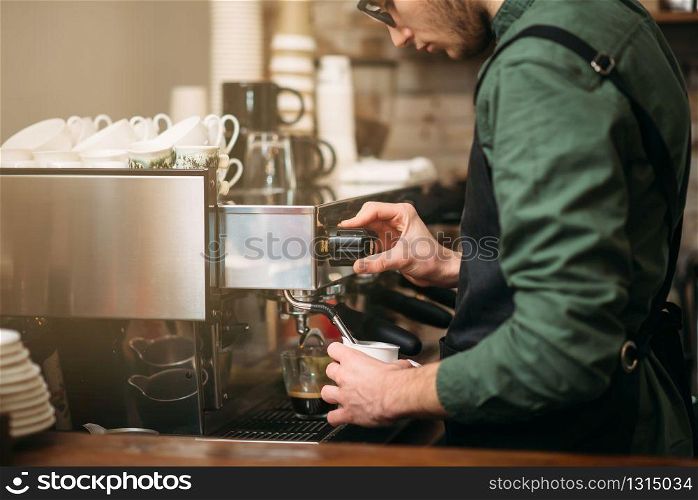 Closeup hands of man who pours coffee from a coffee machine. Man hands pours drink from a coffee machine.