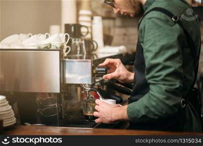 Closeup hands of man who pours coffee from a coffee machine. Man hands pours drink from a coffee machine.
