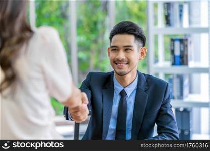 Closeup handshake after interview agreement between Young Asian woman and two manager with positive motion in meeting room, handshake with manager, Business Hiring new member concept,