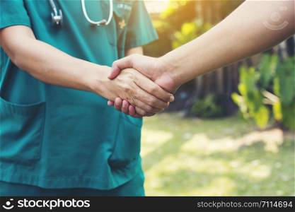 closeup.handshake between doctor green cloth and patient.