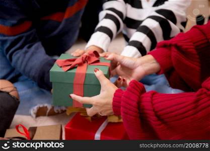 Closeup happy family father and mother giving gift box with daughter on celebration in Christmas day at home, xmas with parent surprising children with enjoyment at house, thanksgiving eve.