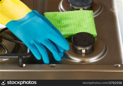 Closeup horizontal image of rubber gloves and microfiber rag on top of stove top range