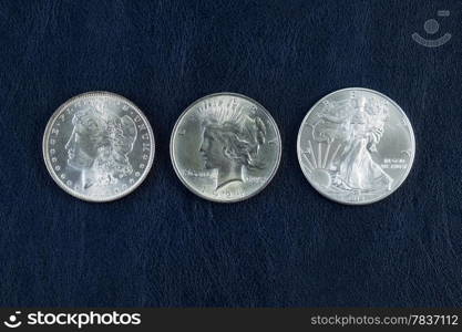 Closeup horizontal photo of a Morgan, Peace and American Silver Eagle Dollars on Blue Vinyl Holder