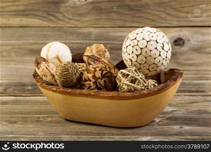 Closeup horizontal photo of home decorations place inside of a wood basket on rustic wooden boards