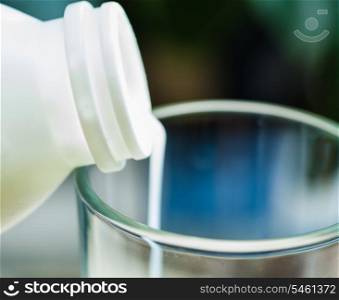 Closeup image of a milk poured in glass cup over indoors background