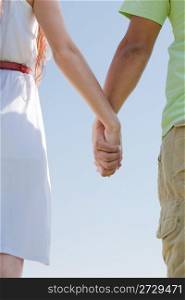 closeup image of a young couple holding hands