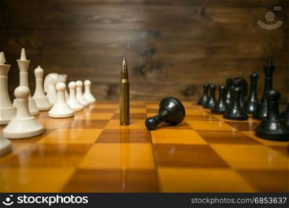 Closeup image of bullet winning in chess game. Concept of power of guns
