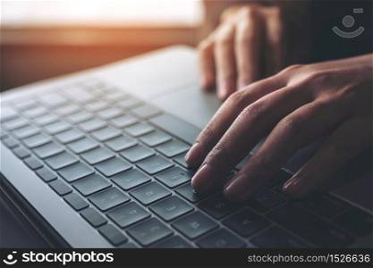 Closeup image of business woman working and typing on laptop keyboard