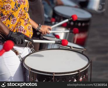 Closeup image of group of musician playing on drums during party or carnival. Closeup photo of group of musician playing on drums during party or carnival