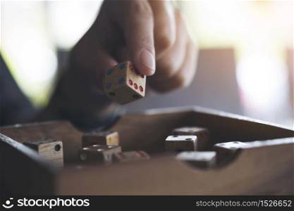 Closeup image of hand holding and playing wooden dices