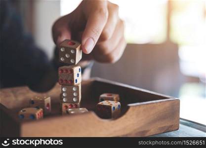 Closeup image of hand playing and building wooden dices