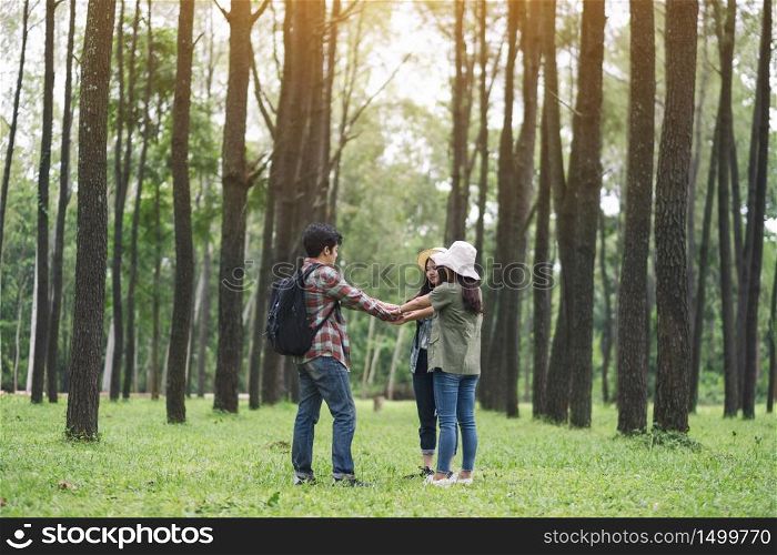 Closeup image of travelers putting their hands together in the forest