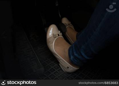 Closeup image of woman in comfortable shoes pressing car pedals
