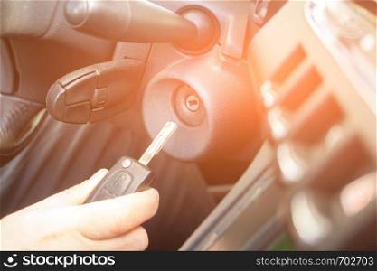 Closeup inside vehicle of hand holding key in ignition, start engine key.. Closeup inside vehicle of hand holding key in ignition, start engine key