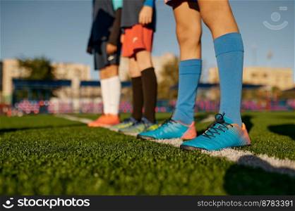 Closeup leg of teenage football player on white line across green soccer lawn with artificial grass. Closeup leg of teenage football player on white line across green lawn
