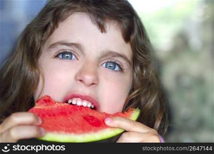 closeup little girl portrait eating watermelon slice blue eyes