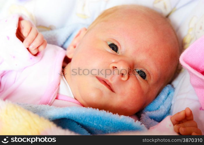 Closeup little newborn baby girl three weeks lying in diaper with open eyes
