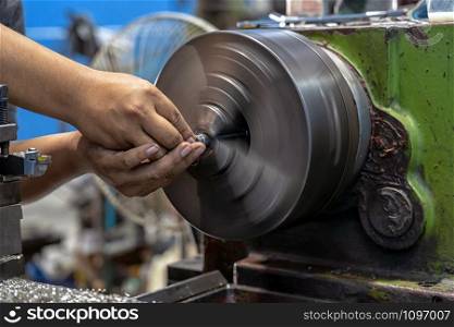 Closeup machinist hand working with lathes machine in metalworking factory, lathe metalworking industry concept