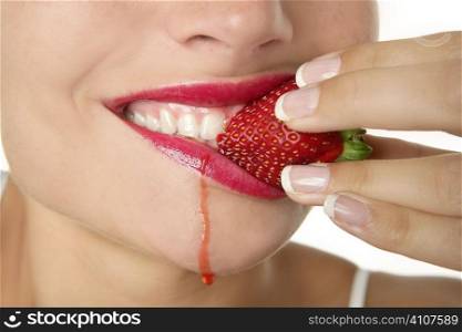 Closeup macro of woman eating a juicy strawberry