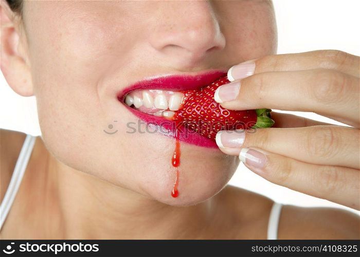 Closeup macro of woman eating a juicy strawberry