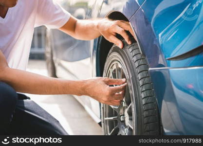 Closeup male automotive technician removing tire valve nitrogen cap for tire inflation service at garage or gas station. Car annual maintenance and repair concept. Safety road trip and travel theme.