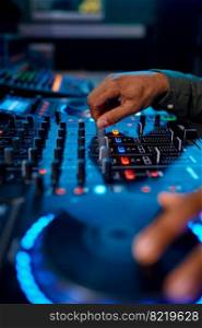 Closeup male hand on sound mixer console surface in recording, broadcasting studio under neon light illumination. Closeup male hand on sound mixer console