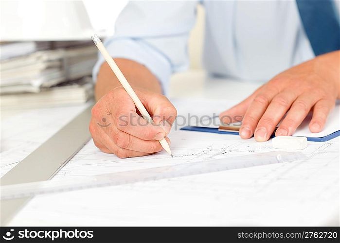 Closeup man hands working on blueprints and construction plans