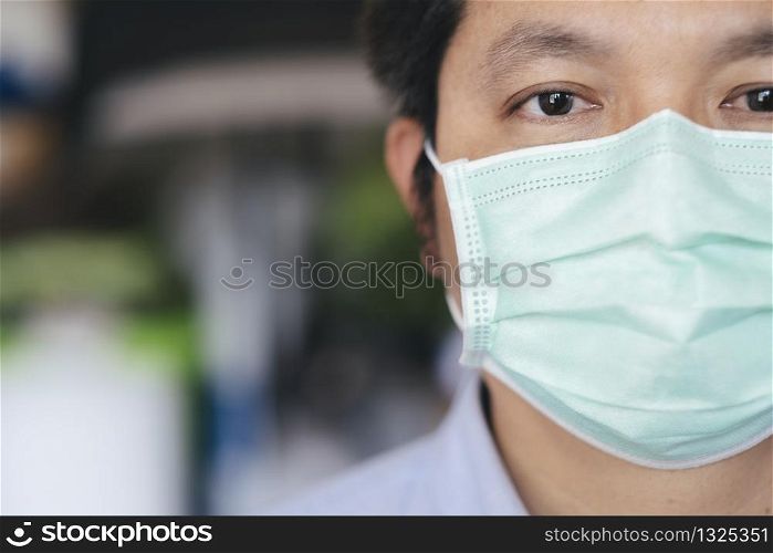 Closeup man wearing hygienic mask to prevent infection, airborne respiratory illness such as flu, 2019-nCoV. Protection against contagious disease, coronavirus.