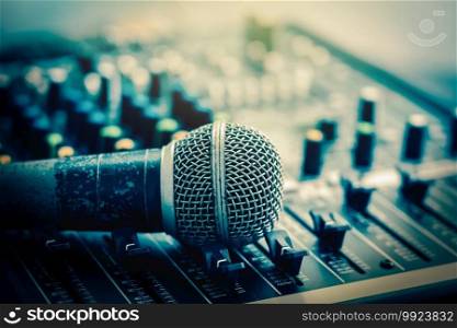 Closeup microphone over the audio mixer, vintage film style, music equipment concept