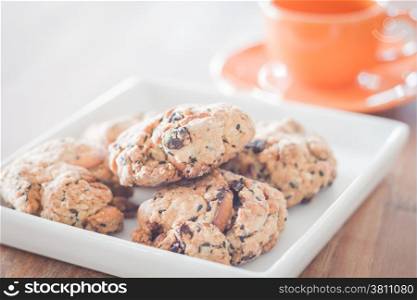 Closeup mixed nut cookies with mini orange coffee cup, stock photo
